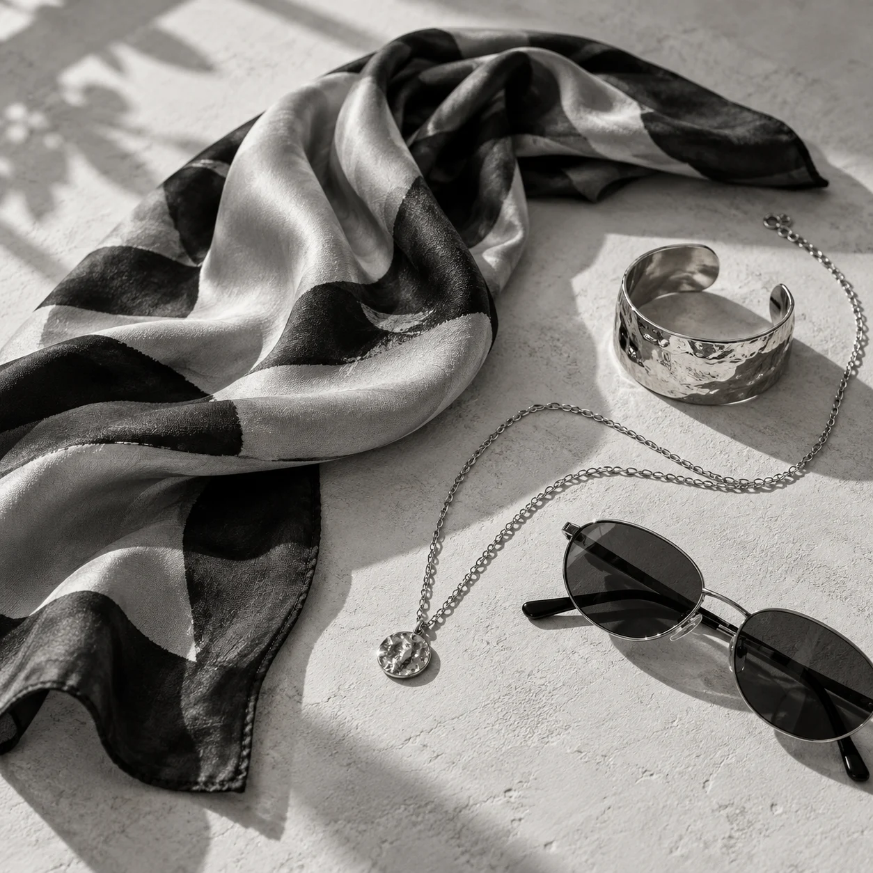 Silk scarf, silver jewellery and dark sunglasses
